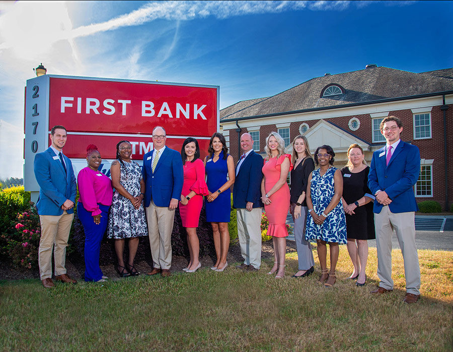 First Bank Florence Main branch employees standing in front of branch sign.