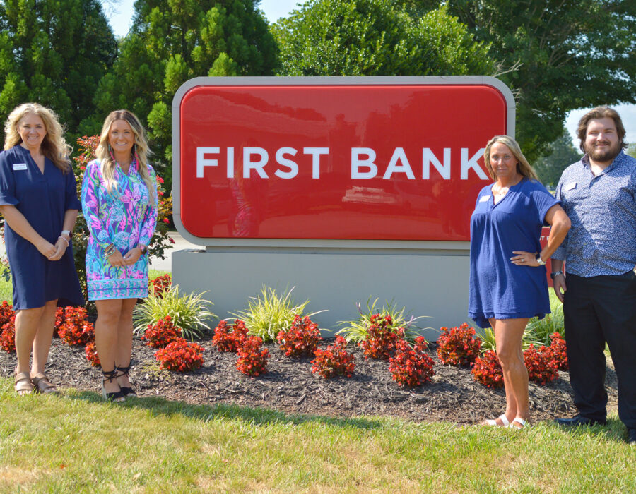 First Bank Harmony Branch exterior, with team standing next to sign.