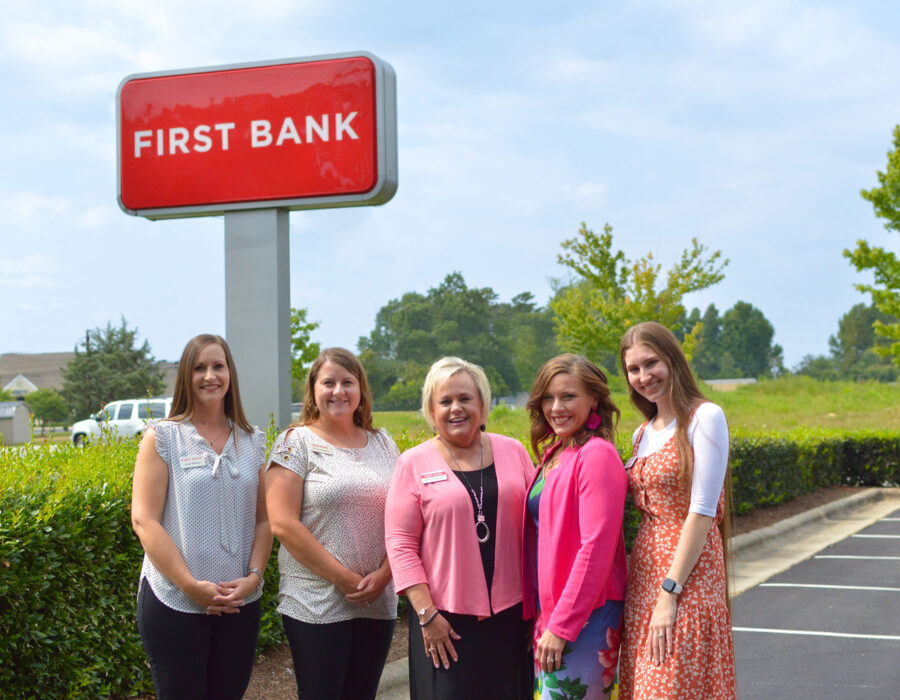 First Bank Thomasville team standing by the exterior sign.