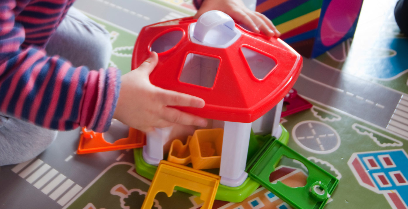 A child's hands playing with toys