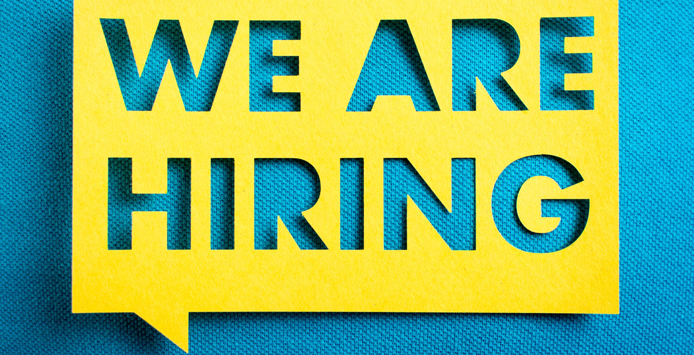 Yellow we are hiring sign on blue background