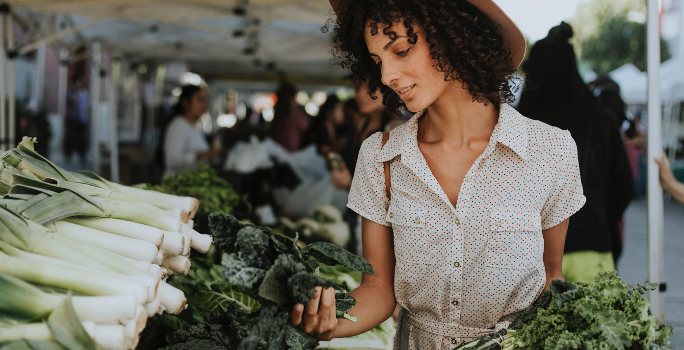 Woman looking at produce in a farmers market
