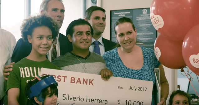 Herrera family holding large check
