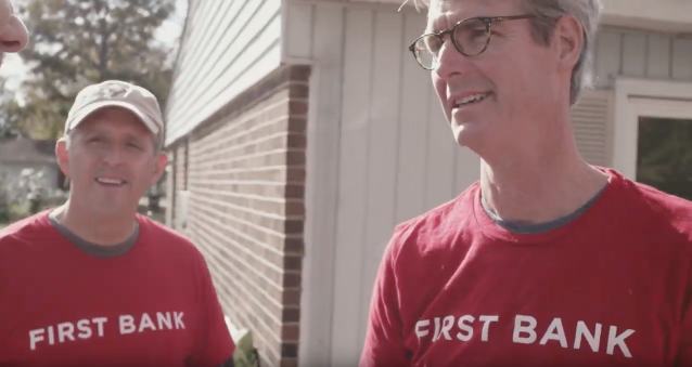 2 men wearing first bank t-shirts