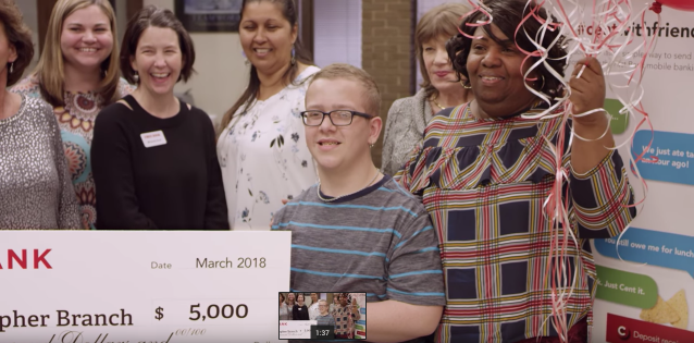 people holding a large check and balloons