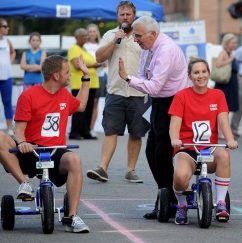 Two First Bank employees riding tri-cycles