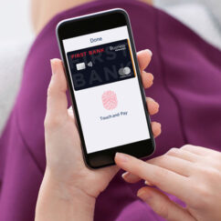 A woman using the Touch ID login for her First Bank Business Credit Card.