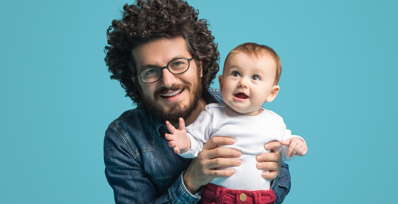 Man holding baby smiling at camera
