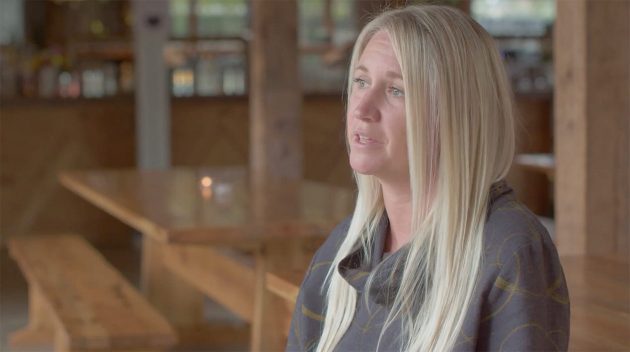 Jessica Reiser smiling with her dog on her lap.