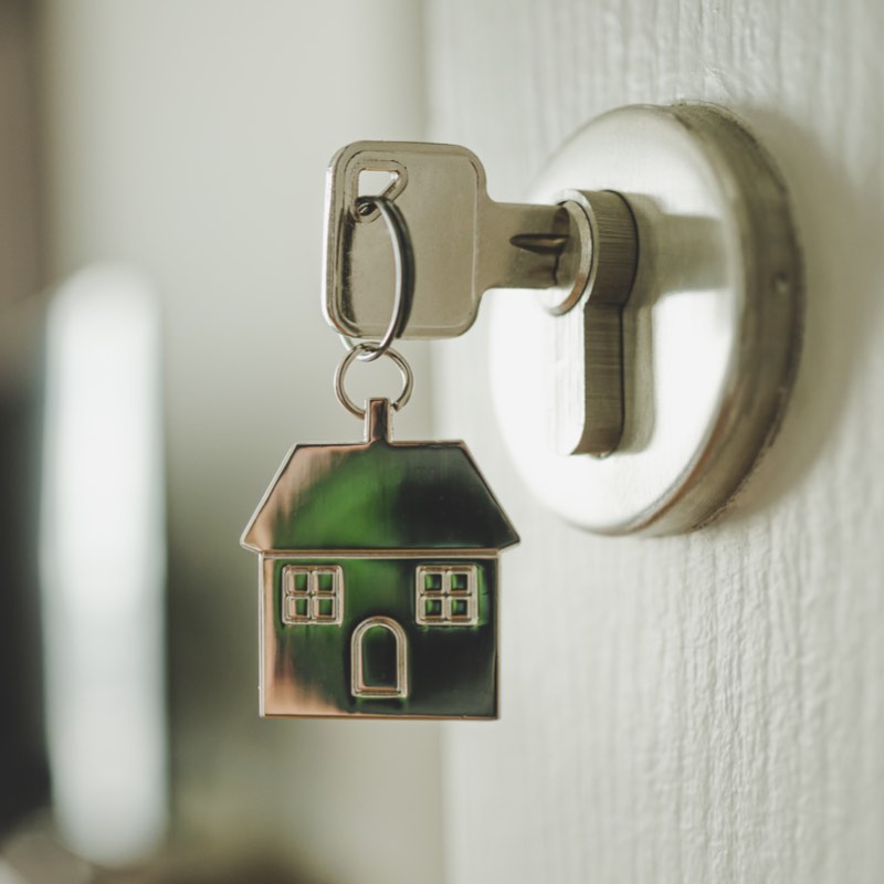 A house key in the lock of a new home.