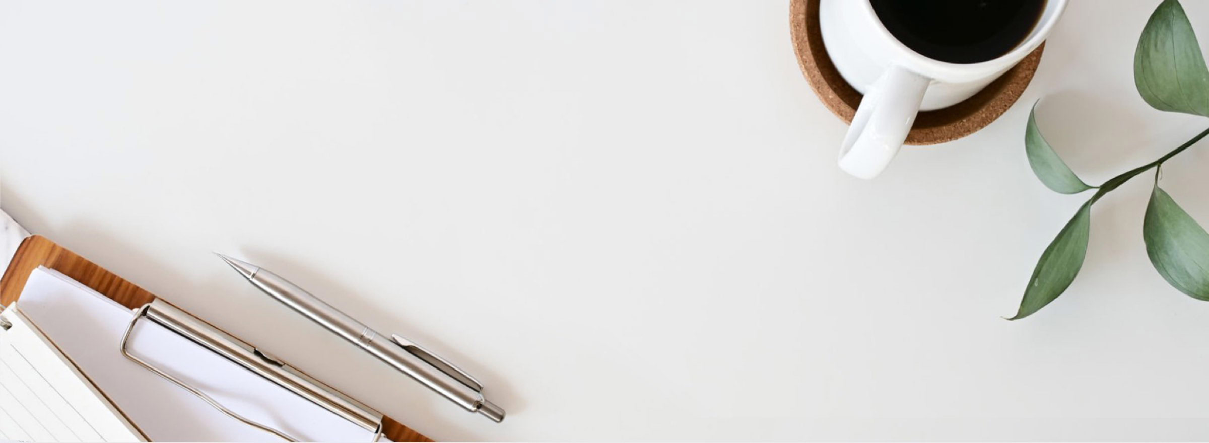 Coffee cup and pens on a desk.