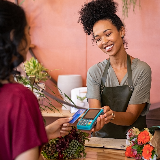 Cashier taking a credit card payment on her reader.